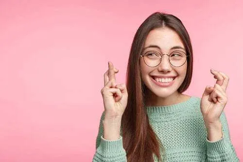 Mulher cruzando os dedos' title='A sorte existe: a ciência diz isso